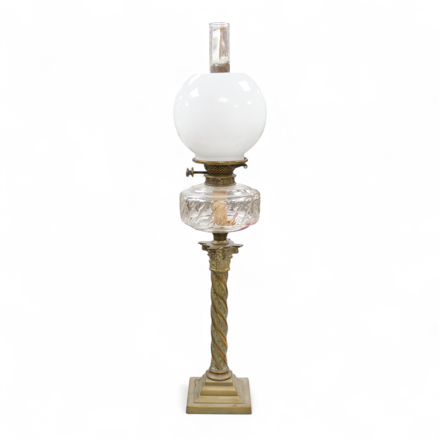 A brass corinthian column oil lamp with glass reservoir and opaque glass shade, 78cm high
